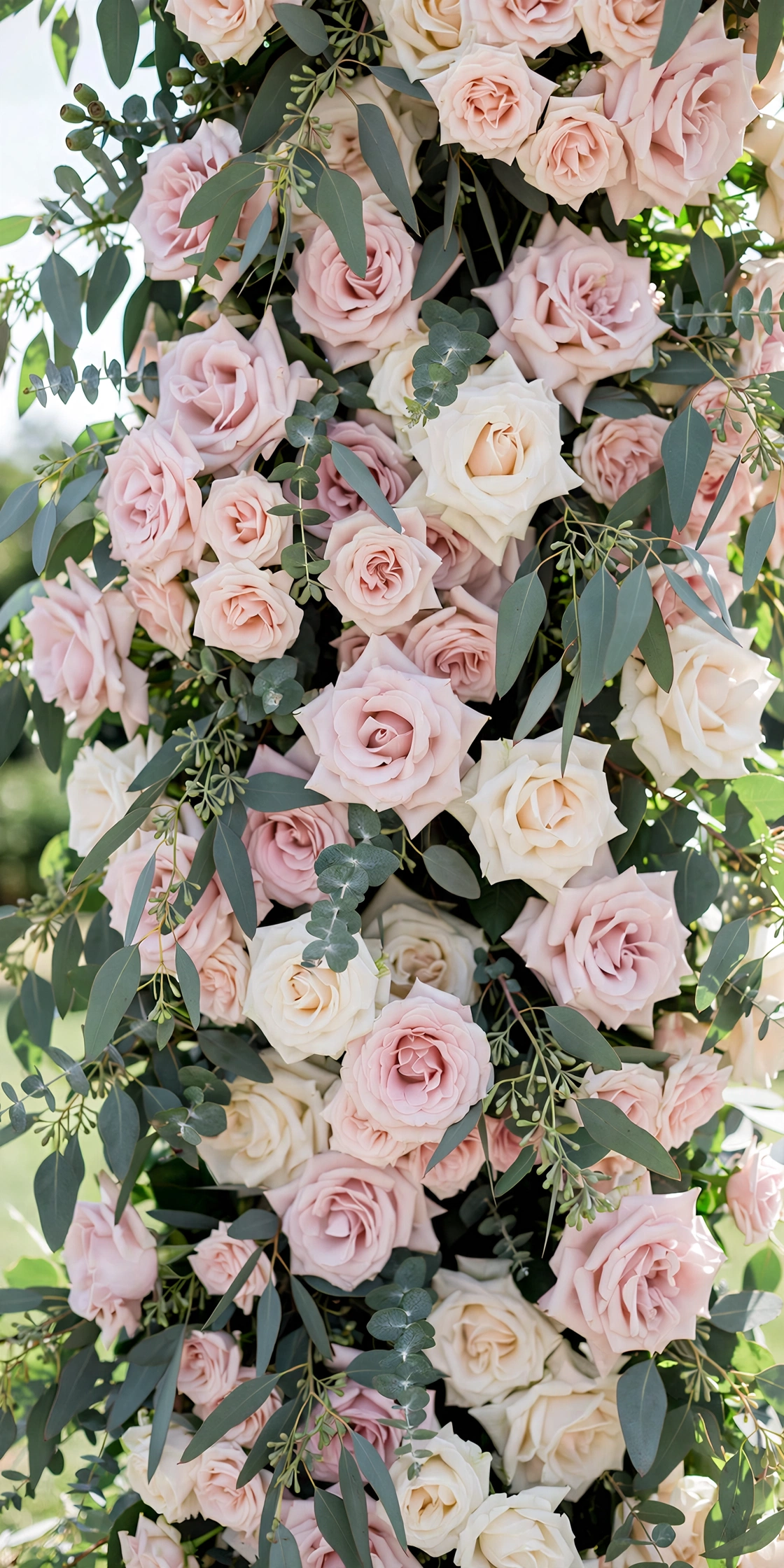 Wedding ceremony backdrop with flowing ivory chiffon drapes and floral pillars