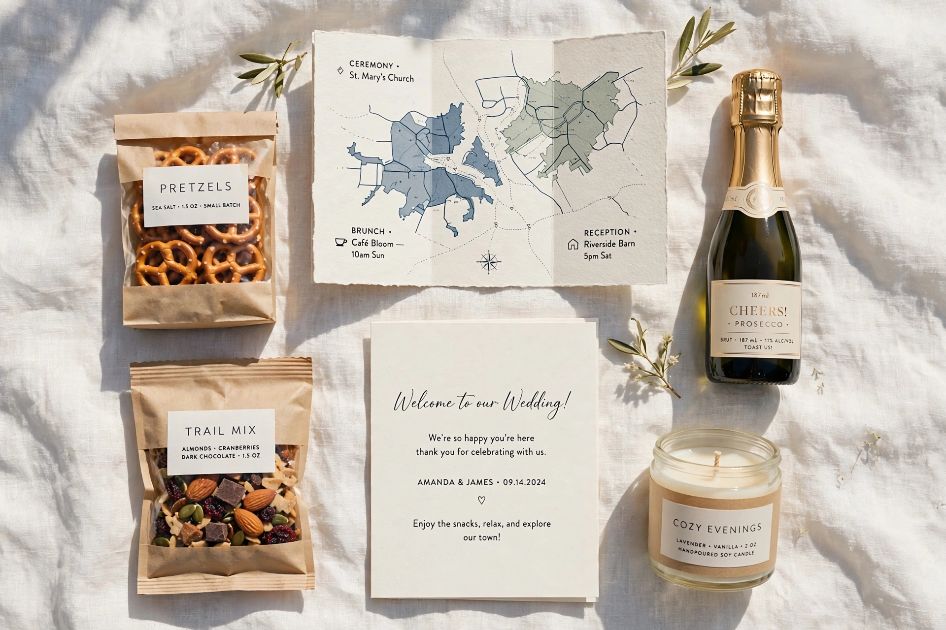 Flat lay of wedding welcome bag contents arranged on white linen