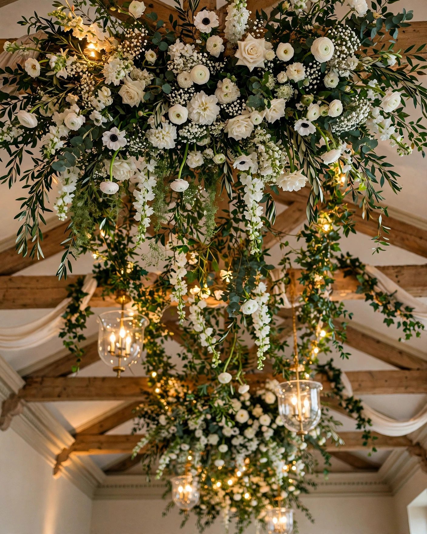 Hanging floral ceiling installation with white flowers and greenery at a wedding