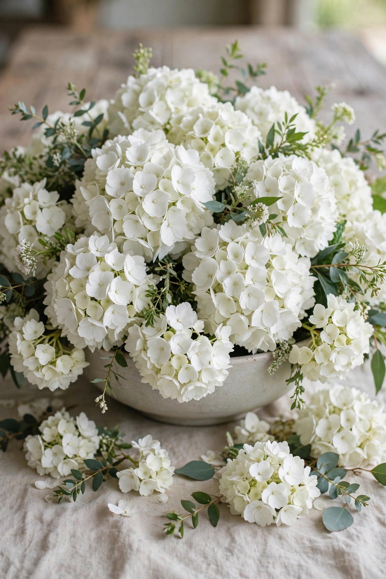 Low bowl overflowing with white hydrangea wedding flowers