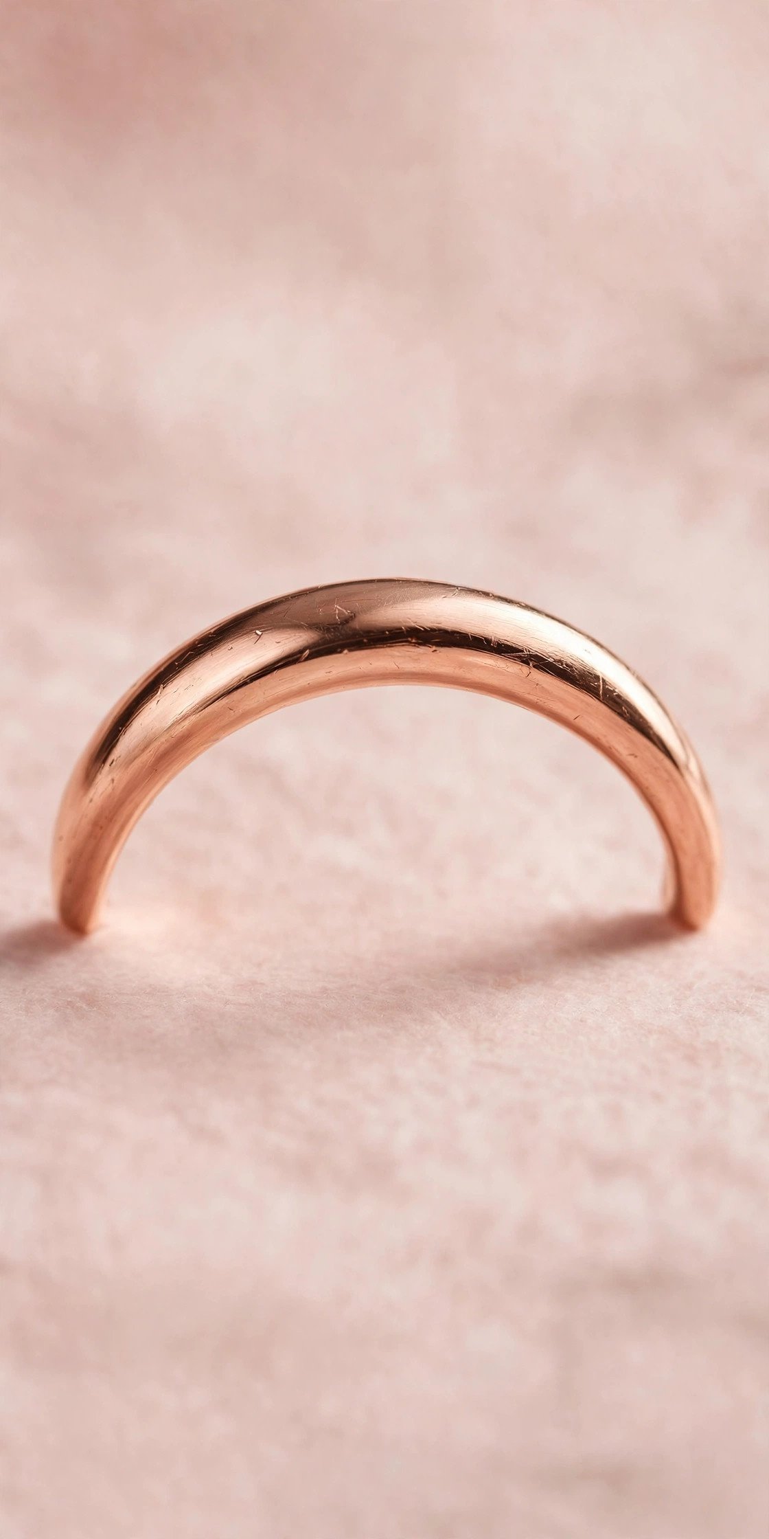 Rose gold curved wedding band with a soft arc