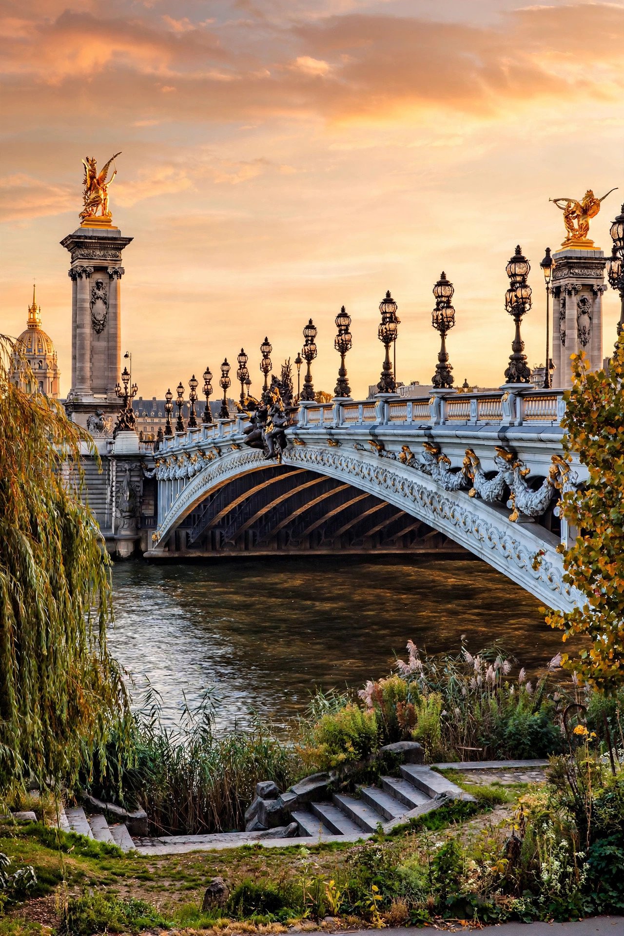 Ornate Pont Alexandre III bridge over the Seine at sunset with golden statues